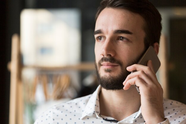 Schöner Mann der Vorderansicht, der über Telefon spricht