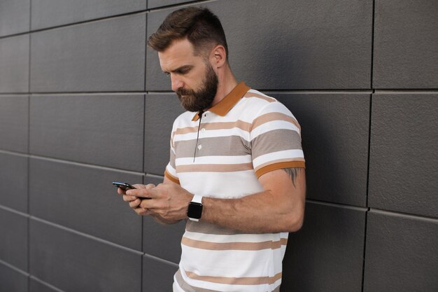 schöner Mann mit Handy im Freien