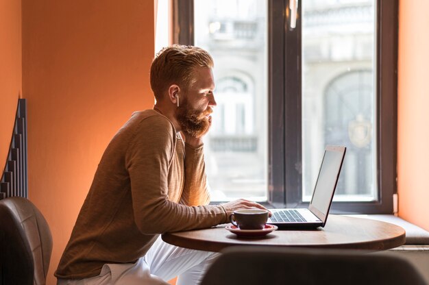 Schöner moderner Mann der Seitenansicht, der arbeitet