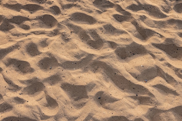 Schöner natürlicher Sand des Strandhintergrundes bei Sonnenuntergang