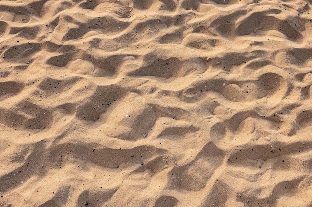 Schöner natürlicher Sand des Strandhintergrundes bei Sonnenuntergang