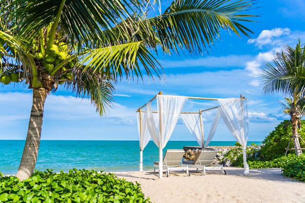 Schöner Regenschirm und Stuhl um Strandseeozean mit blauem Himmel für Reise