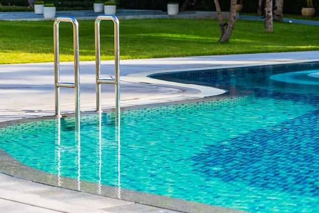 Schöner Regenschirm und Stuhl um Swimmingpool im Hotelerholungsort für Feiertagsferienreise