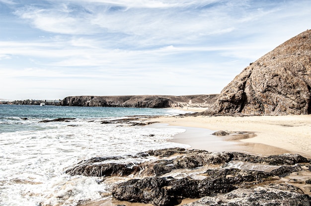 Schöner Schuss des Strandes und des blauen Ozeans in Lanzarote, Spanien an einem sonnigen Tag