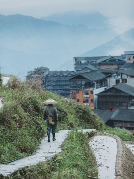 Schöner Schuss einer Person, die durch einen Tonweg einer Terrasse in einer chinesischen Stadt geht