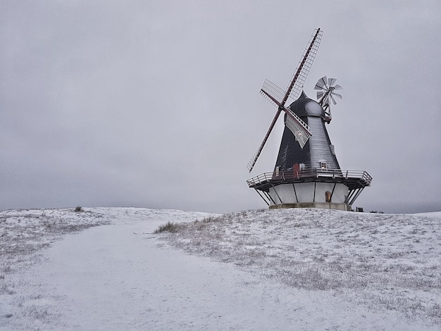 Schöner Schuss einer Windmühle in der Mitte eines Winterfeldes