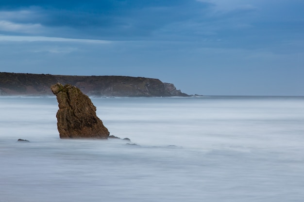 Schöner Schuss eines Felsens, der aus dem Wasser im Meer herausragt