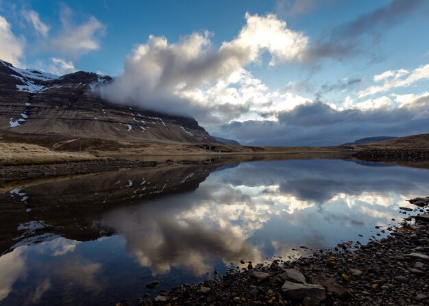 Schöner Schuss eines felsigen Feldes mit einem See und atemberaubendem Himmel