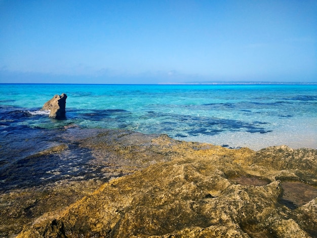 Schöner Schuss eines felsigen Strandes in Formentera, Spanien