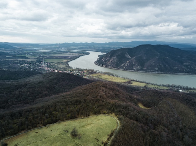 Schöner Schuss eines Flusses zwischen Hügeln unter dem bewölkten Himmel