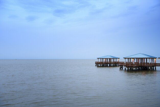 Schöner Schuss eines hölzernen Piers auf dem Meer unter dem bewölkten Himmel