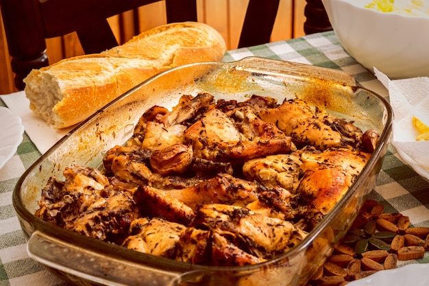 Schöner Schuss eines Huhns mit Soße in der Pfanne und Brot auf dem Tisch