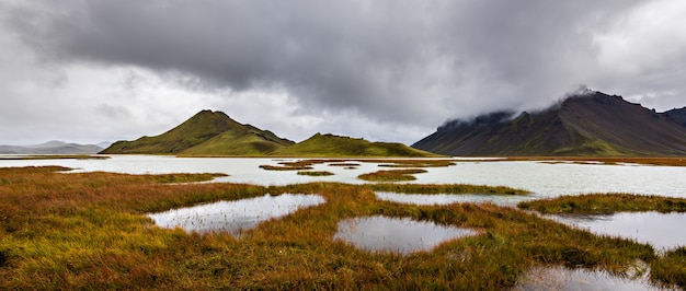 Schöner Schuss von Bergen in der Hochlandregion von Island mit einem bewölkten grauen Himmel im Hintergrund