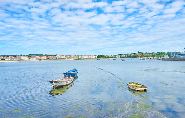 Kostenloses Foto schöner schuss von booten auf dem wasser unter einem hellen bewölkten himmel