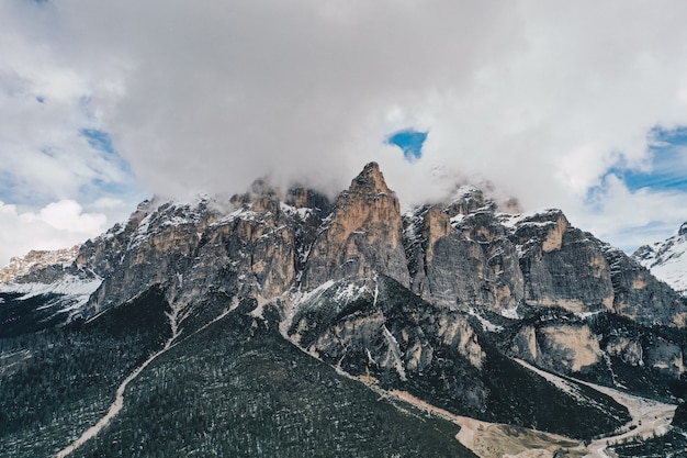 Kostenloses Foto schöner schuss von hohen felsigen bergen mit erstaunlichen wolken im blauen himmel
