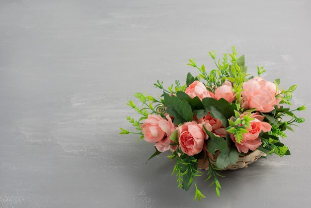 Schöner Strauß der rosa Rosen auf grauem Tisch.