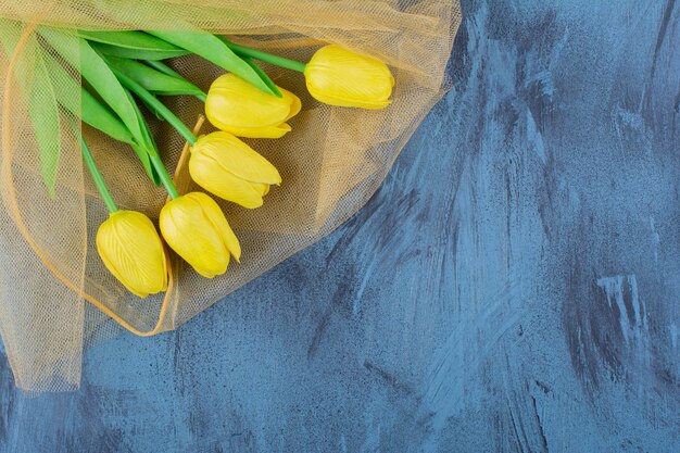 Schöner Strauß frischer gelber Tulpen auf Blau.