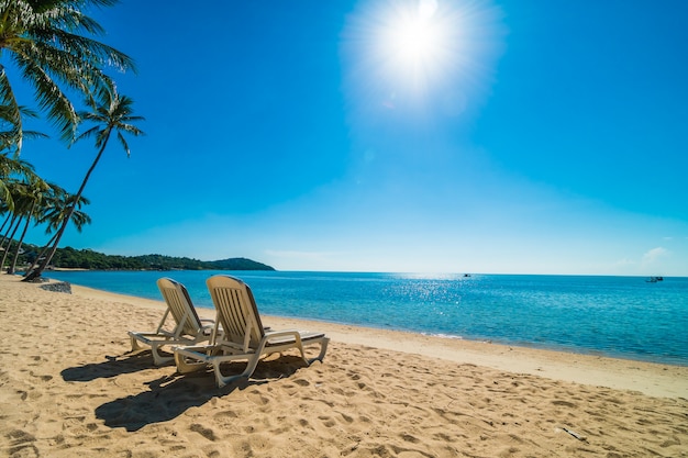 Schöner tropischer Strand und Meer mit Stuhl auf blauem Himmel