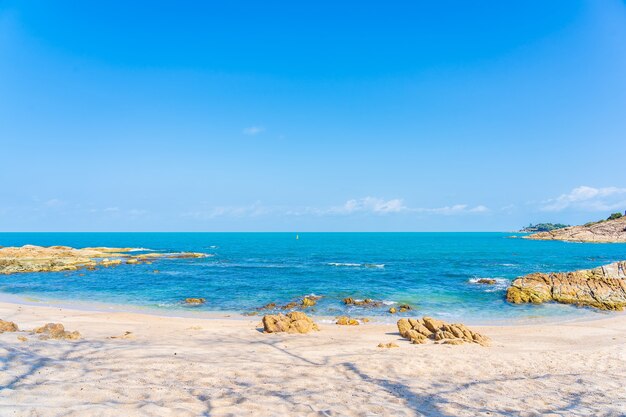 Schöner tropischer Strandmeeresozean mit Kokospalme um weißen Wolkenblauen Himmel für Urlaubsreisehintergrund