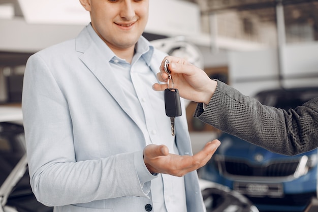 Kostenloses Foto schöner und eleganter mann in einem autosalon