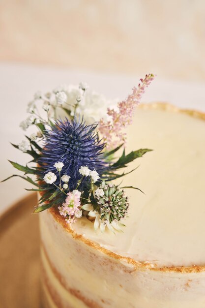 Schöner und köstlicher Kuchen mit Blume und goldenen Rändern auf einer weißen Oberfläche