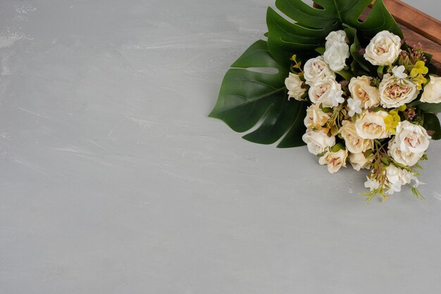 Schöner weißer Rosenstrauß auf grauer Oberfläche.