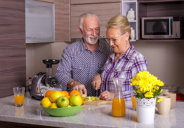 Schönes älteres Ehepaar, das in der Küche miteinander kocht