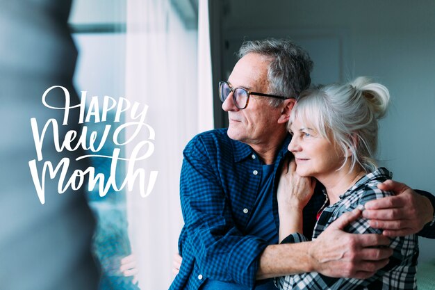 Schönes älteres Paar mit froher neuer Monatsbeschriftung