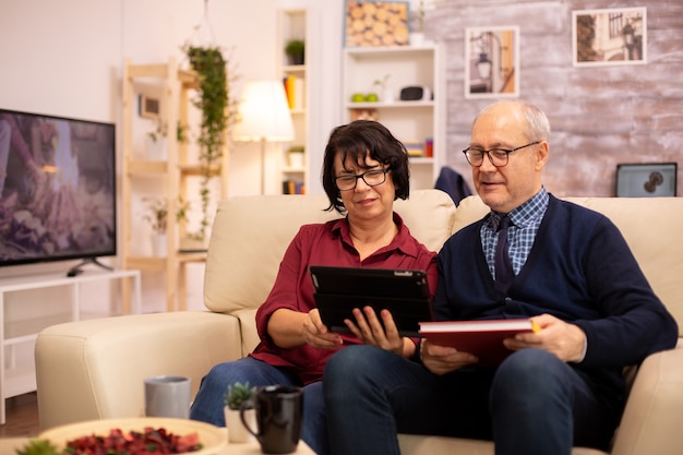 Schönes altes Paar, das ein digitales Tablet verwendet, um mit ihrer Familie zu chatten. Ältere Menschen mit moderner Technologie