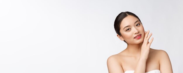 Schönes asiatisches Frauenmake-up der kosmetischen Mädchenhandberührungswange und Lächelngesicht der Schönheit perfekt mit Wellness lokalisiert auf weißem Hintergrund