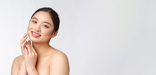 Schönes asiatisches Frauenmake-up der kosmetischen Mädchenhandberührungswange und Lächelngesicht der Schönheit perfekt mit Wellness lokalisiert auf weißem Hintergrund