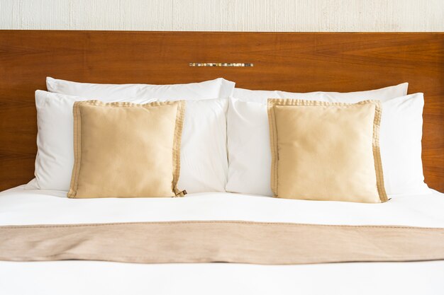 Schönes bequemes weißes Luxuskissen und Decke auf Bettdekoration im Schlafzimmer