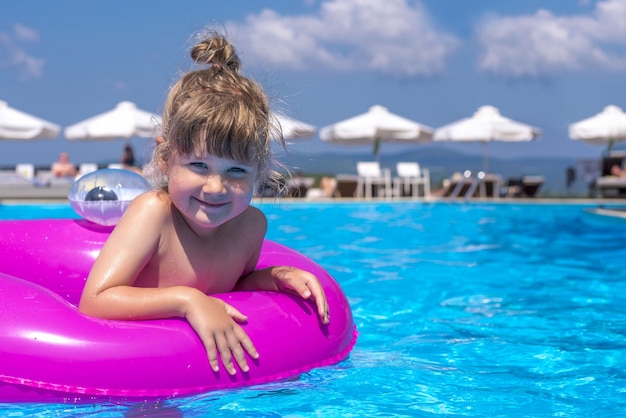 Schönes Bild eines Kindes in einem Schwimmbad im Sonnenlicht
