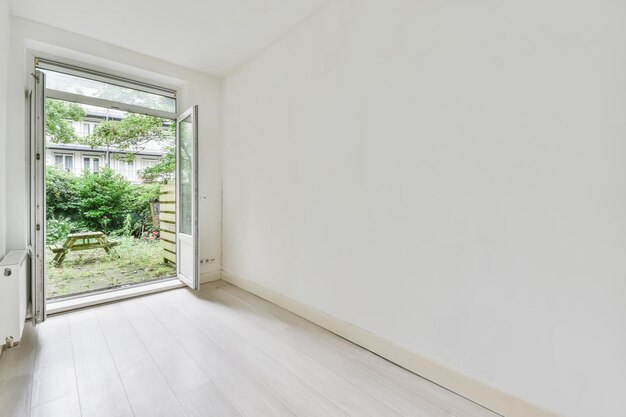 Schönes Bild eines leeren Raums mit einem Überschuss zum Gartenbereich in einem weißen Innenarchitekturhaus