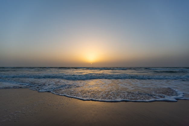 Schönes Bild eines Sonnenuntergangs von einem Strand unter einem blauen Himmel im Senegal