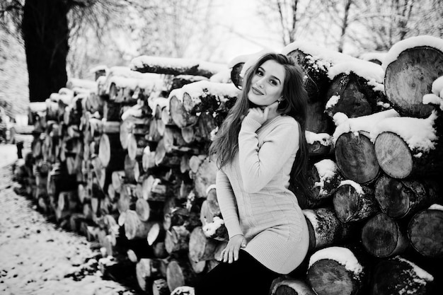 Schönes brünettes Mädchen in warmer Winterkleidung Modell auf Winterpullover in der Nähe von Stumpf