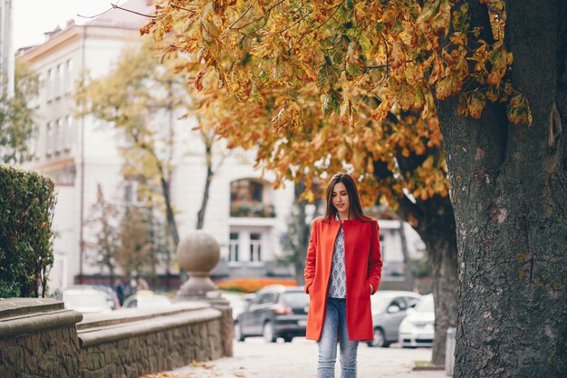 schönes elegantes Mädchen, das um die Herbststadt geht