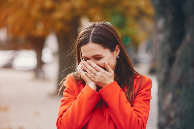 schönes elegantes Mädchen, das um die Herbststadt geht