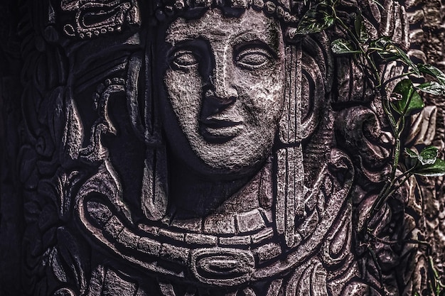 Schönes felsiges Denkmal mit einem geschnitzten Bild eines menschlichen Gesichts im Dschungel. Nahaufnahme