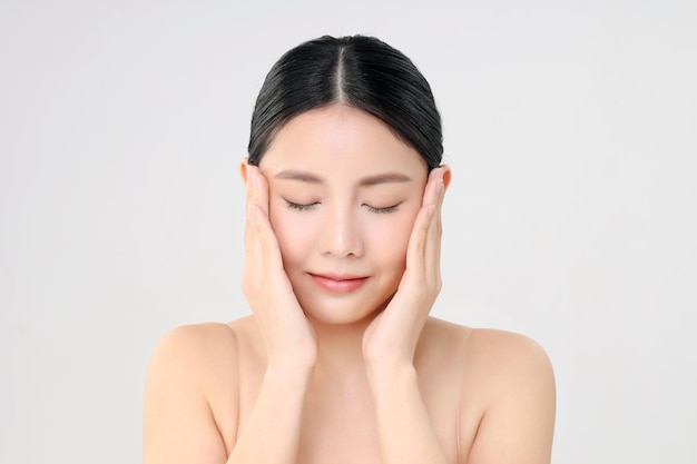 Schönes Gesicht der jungen erwachsenen asiatischen Frau mit sauberer frischer Haut lokalisiert auf Weiß