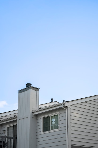 Schönes Haus mit Kamin und blauem Himmel