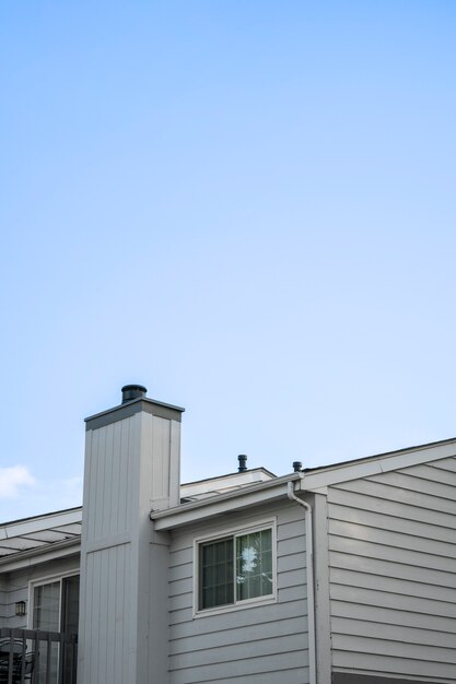 Schönes Haus mit Kamin und blauem Himmel