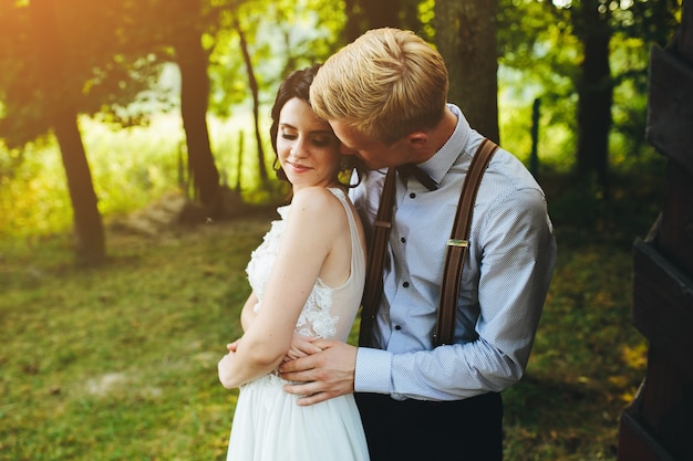 Schönes Hochzeitspaar, das in einem Wald aufwirft