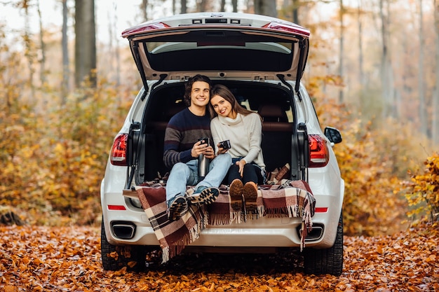 Schönes hübsches Paar, das Picknickzeit im Wald genießt