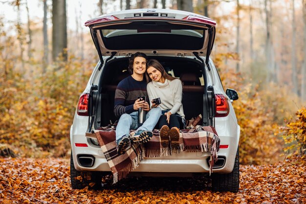 Schönes hübsches Paar, das Picknickzeit im Wald genießt