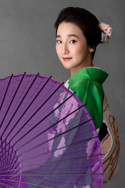 Schönes japanisches Model mit lila Regenschirm