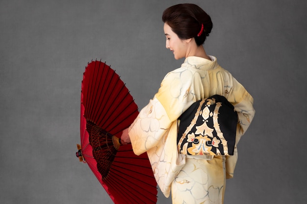 Schönes japanisches Model mit rotem Regenschirm
