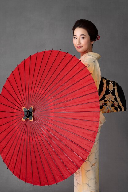 Schönes japanisches Model mit rotem Regenschirm