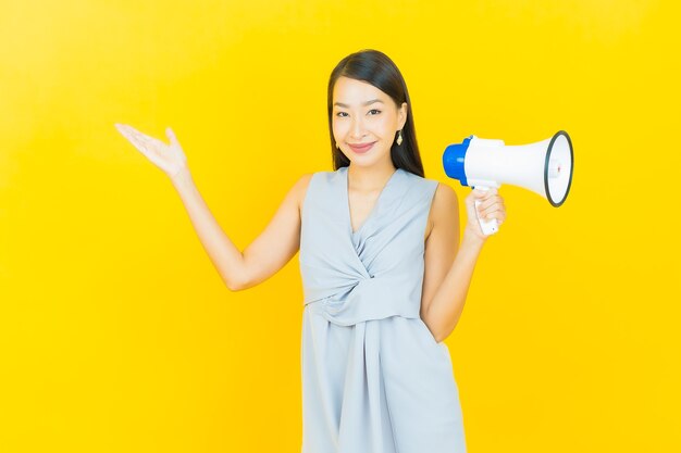 Schönes junges asiatisches Frauenlächeln des Porträts mit Megaphon
