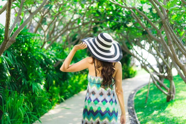 Schönes junges asiatisches Frauenlächeln des Porträts und glücklich um Garten im Freien